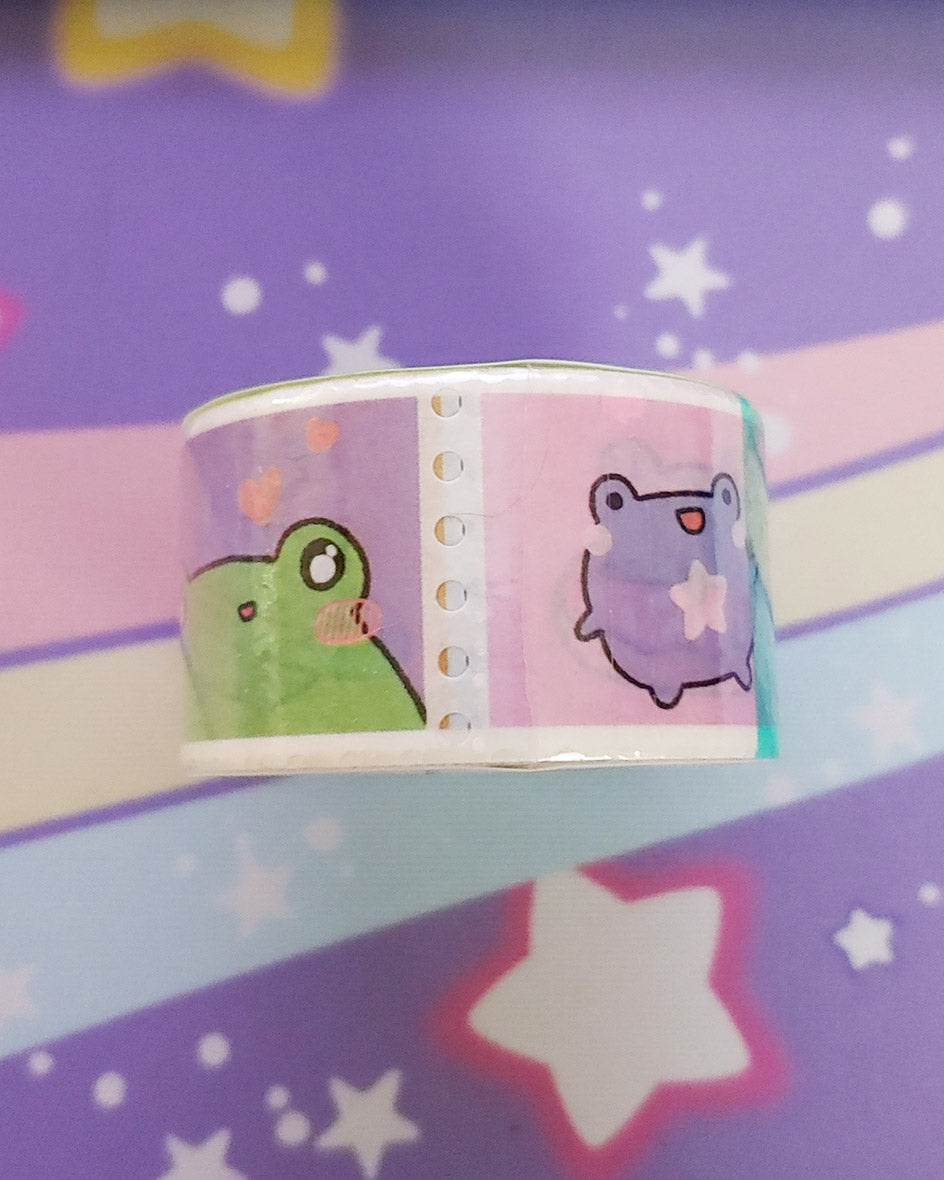 One side of the cute kawaii frog froggy paper washi tape.  Featuring pastel colors of green, purple, and pink.