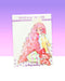 A teenage looking kawaii manga girl who is wearing white bunny ears and has long pink wavy hair. She is sitting with her knees bent and her legs off to the side. She is wearing pink and green striped leggings, a pink skirt, pink high heeled boots, and a yellow furry light jacket. This digital art piece is printed on a broken glass holographic vinyl sticker.