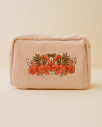 Bolsa de maquillaje de pana con bordado floral rojo y naranja en color arena blanca
