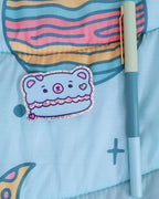 A blue and pink macaron cookie digital artwork shaped like a kawaii bear with hot pink, glitter green, and pastel pink heart sprinkle candies decorating it.  The macaron filling is pink glitter.  All of this is printed on a glossy vinyl sticker.  The sticker is placed next to a pen to show how big the sticker is compared to another object