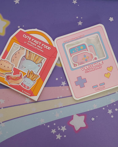 Photo shows both the kawaii cute fast food sticker pack and the video game sticker pack next to each other.