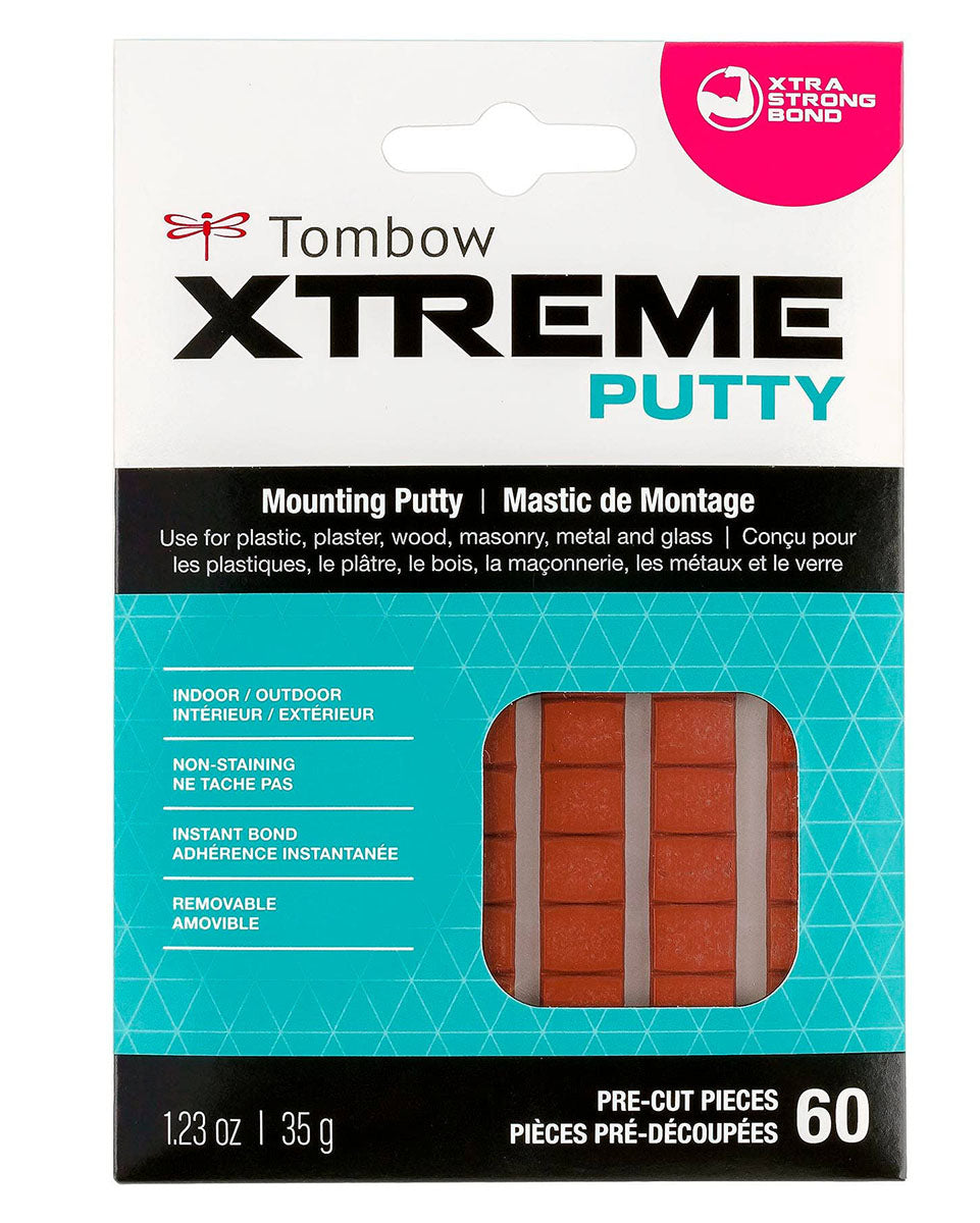 Tombow Xtreme Mounting Putty.  "Use for plastic, plaster, wood, masonry, metal, and glass"  Indoor/Outdoor. 60 pre-cut pieces. 1.23 oz | 35 g.  Image also shows the brown rectangular putty pieces through a window and a hot pink partial circle in the corner that reads "xtra strong bond"