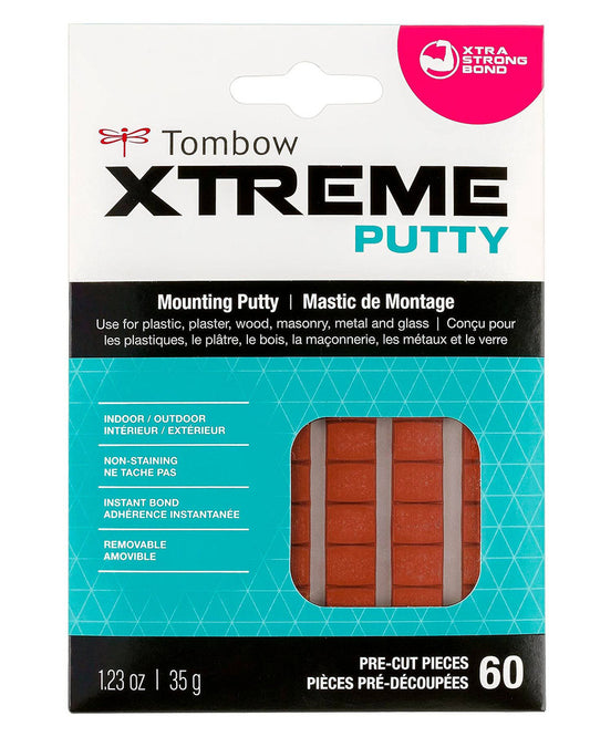 Tombow Xtreme Mounting Putty.  "Use for plastic, plaster, wood, masonry, metal, and glass"  Indoor/Outdoor. 60 pre-cut pieces. 1.23 oz | 35 g.  Image also shows the brown rectangular putty pieces through a window and a hot pink partial circle in the corner that reads "xtra strong bond"