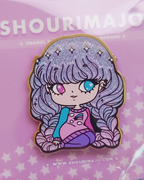 A girl with beautiful glittery and sparkly purple and pink gradient/ombre hair sitting with her legs bent.  She has two different colored eyes: one pink and one blue.  She is wearing a pink and blue and pullover sweater with a shooting star and clouds on it.  She also had purple leggings and she is looking off to the side.  This beautiful design is shown on a hard enamel lapel pin.