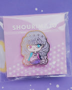 A girl with beautiful glittery and sparkly purple and pink gradient/ombre hair sitting with her legs bent.  She has two different colored eyes: one pink and one blue.  She is wearing a pink and blue and pullover sweater with a shooting star and clouds on it.  She also had purple leggings and she is looking off to the side.  This beautiful design is shown on a hard enamel lapel pin.  It's attached to a purple card with stars on it.