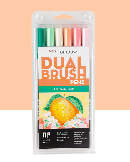 A pack of six brush pen markers from Tombow called "Just Peachy". The colors included are 296 Green, 243 Mint, 020 Peach, 873 Coral, 803 Pink Punch, and 761 Carnation. The outside packaging has an image of a peach on it. It reads dual brush pens as well as brush and fine tip in one pen. Water-based ink and blendable. On an orange and white background.