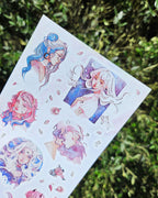 pink foiled paper stickers featuring pink and blue haired women against a green bush backdrop.