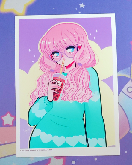 A pastel pink, mint green, purple, and yellow digital art print featuring a kawaii manga girl with pink hair and big light blue eyes.  She is wearing purple glasses and a mint heart sweater pullover.  In her hand, she is holding a boba tea with a kitty cat printed on the outside of the cup.  This is printed on high quality photo paper.