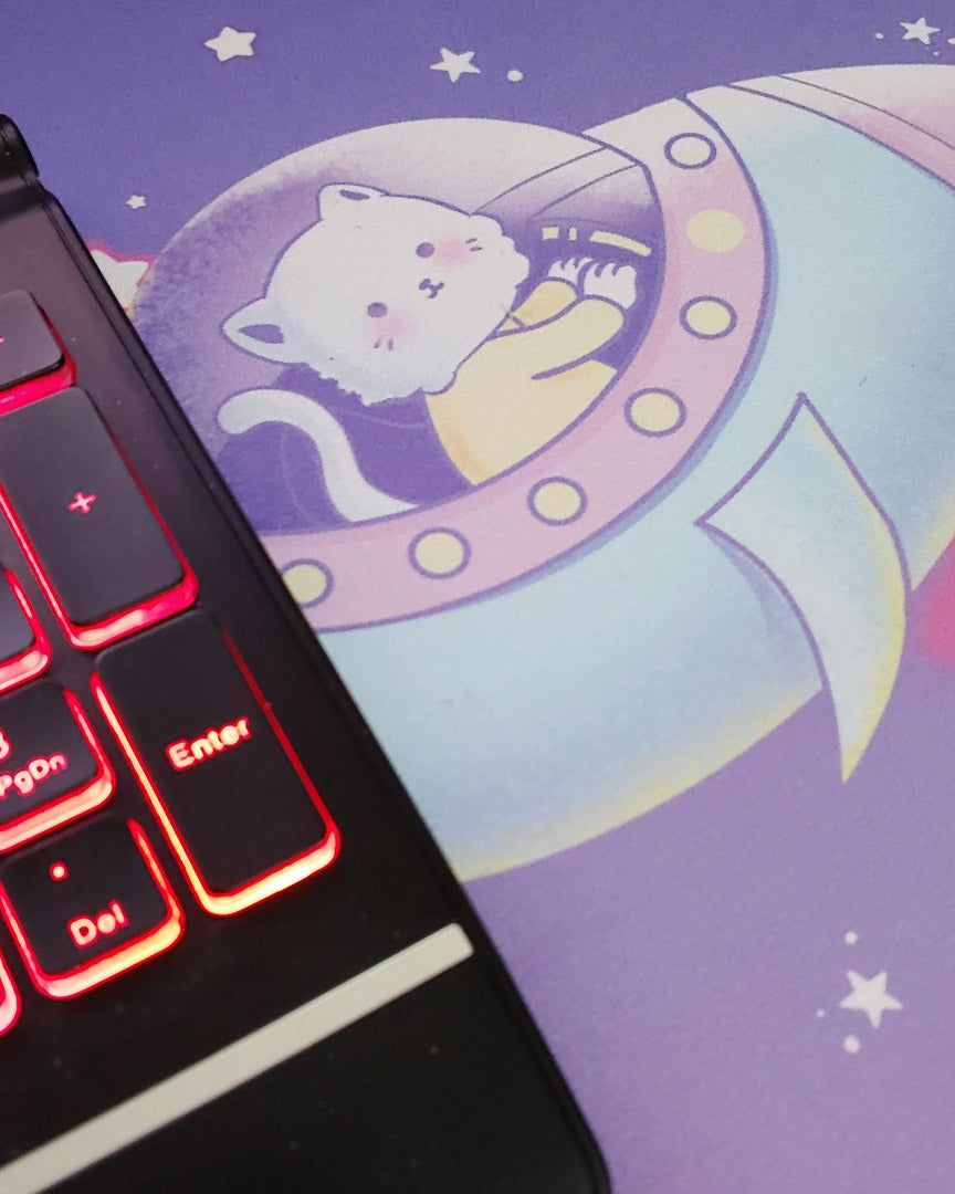 A little white blushing fluffy kitty with a yellow shirt commands a pastel yellow, pink, and blue space ship.  The space ship is surround by a purple sky with white stars.