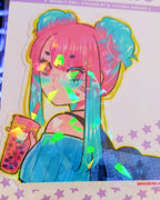 A pink and blue gradient haired girl w/2 buns on her head.  She has pink eyes & blue translucent heart shaped glasses.  She is wearing a blue striped off the shoulder shirt & a dark blue polka dot backpack with a star on it.  She is holding a pink boba tea drink that has a pink straw & a kitty cat printed on the outside of the cup.  She also has a white heart on her shoulder.  All of this kawaii manga digital art illustration is printed with a white border on a broken glass holographic vinyl sticker.