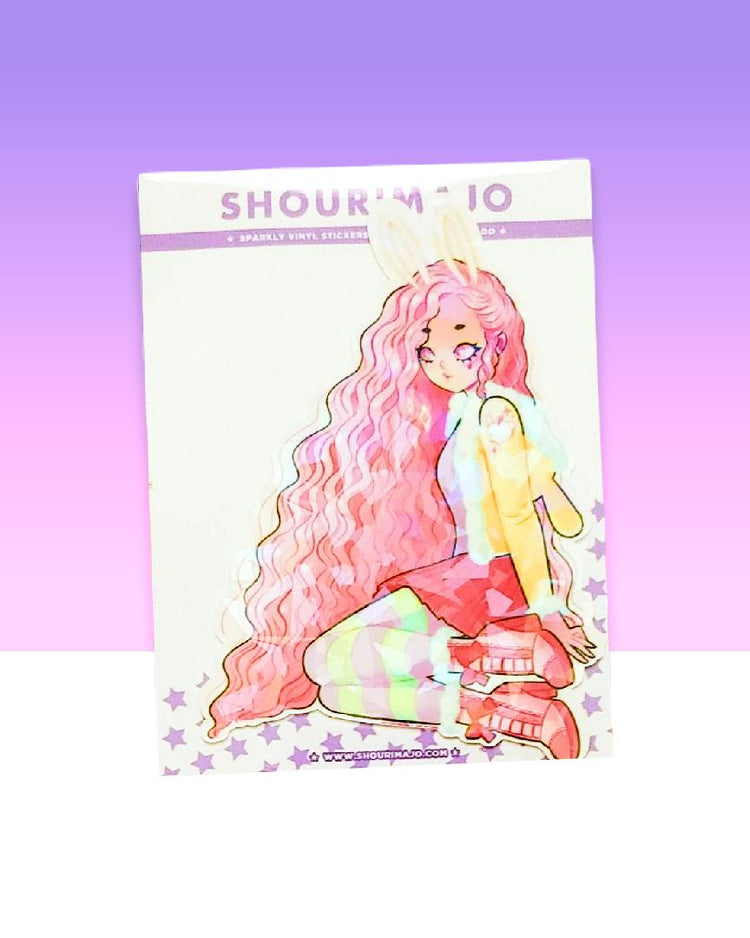 A teenage looking kawaii manga girl who is wearing white bunny ears and has long pink wavy hair.  She is sitting with her knees bent and her legs off to the side.  She is wearing pink and green striped leggings, a pink skirt, pink high heeled boots, and a yellow furry light jacket.  This digital art piece is printed on a broken glass holographic vinyl sticker.